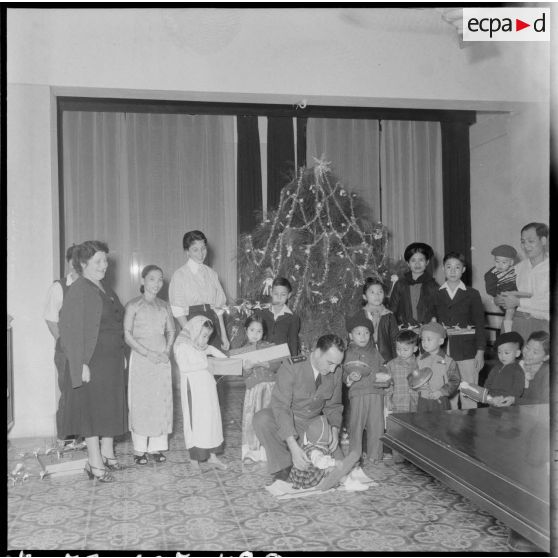 La fille (à côté du sapin) et l'épouse du général Cogny (à gauche), commandant en chef des FTNV (forces terrestres du Nord-Vietnam), lors d'une fête de Noël.