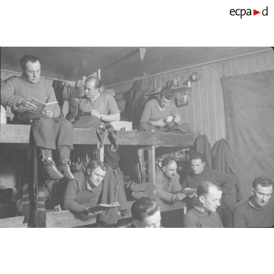 Tuer le temps : les uns lisent, d'autres cousent, d'autres dorment... [légende publiée en 1949]