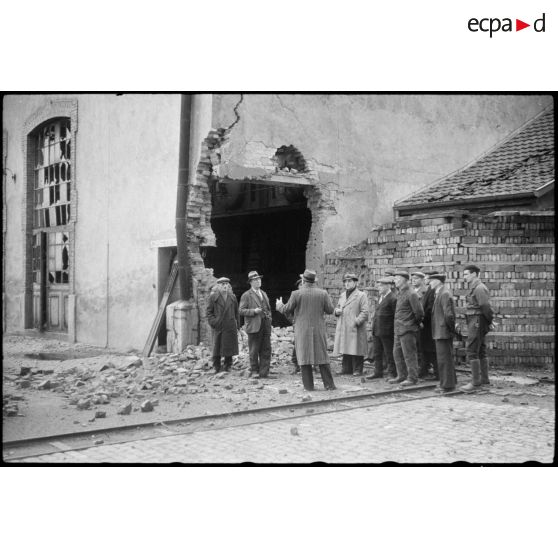Dirigeants d'une filature à Sélestat (Bas-Rhin) devant leur entreprise en ruine.