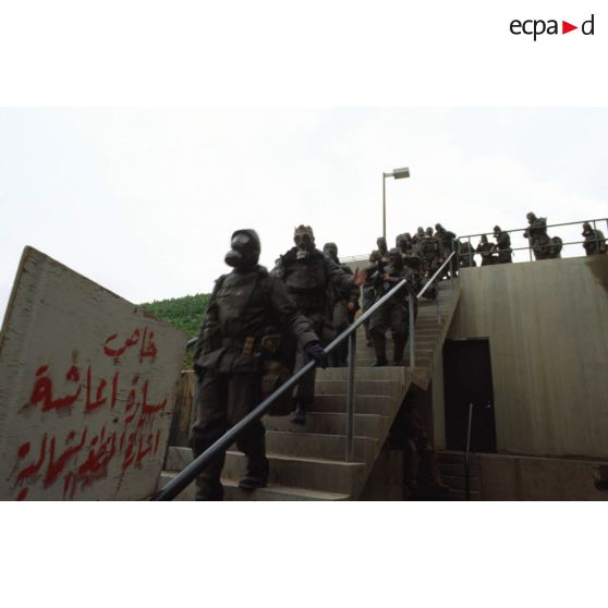 Alerte NBC (risque nucléaire, bactériologique et chimique) au CRK (camp du roi Khaled) : les soldats, revêtus de la tenue S-3P (survêtement de protection à port permanent), descendent vers des abris souterrains.