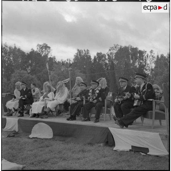 Fête de la Sainte-Barbe et de la Saint-Eloi à la base navale de Lartigue. Des soldats déguisés assis aux côtés des autorités.