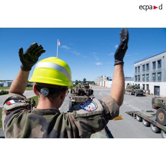 Le brigadier-chef Ludovic du 503e régiment du train (RT) guide le chargement des engins blindés de reconnaissance et de combat (EBRC) Jaguar à bord de porte-chars modulaires (PCM) Sisu à Tapa, en Estonie.